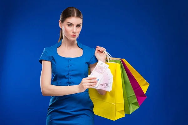 Menina morena com sacos de compras e dinheiro — Fotografia de Stock