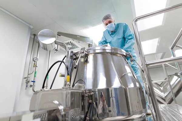 Scientist looks in steel tank in laboratory — Stock Photo, Image