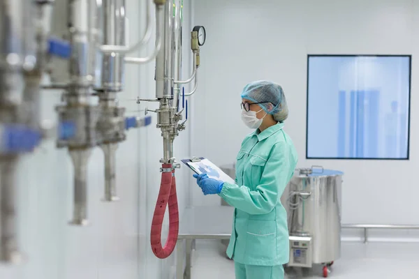 Scienziato in piedi vicino al serbatoio in fabbrica — Foto Stock