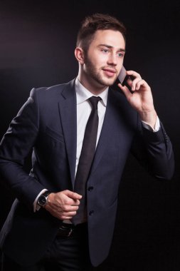 Genç işadamı telefonda konuşuyor.