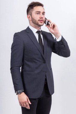 Genç işadamı telefonda konuşuyor.