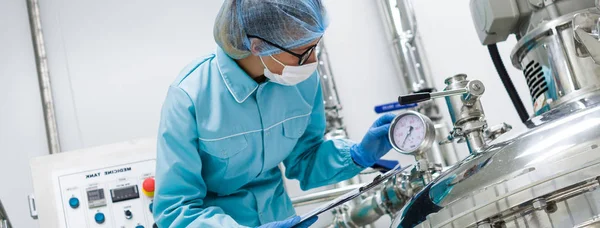 Scientist standing near tank in factory — Stock Photo, Image