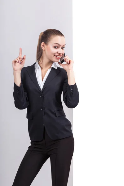 Young businesswoman with phone next to a whiteboard — Stock Photo, Image