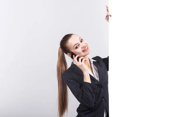 Jonge zakenvrouw met telefoon naast een whiteboard — Stockfoto