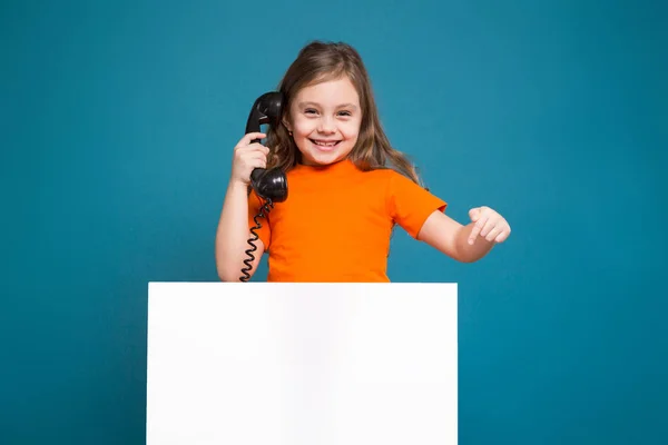 Roztomilá brunetka s telefonem a plakát — Stock fotografie