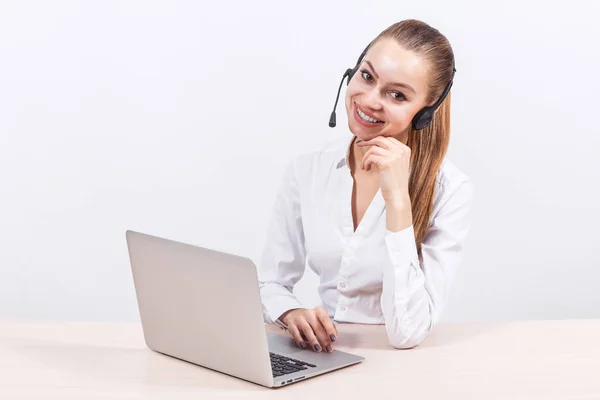 Girl with headset in front of a laptop — Stock Photo, Image