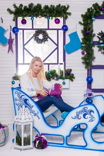 Blond kvinna på en släde med julklapp — Stockfoto