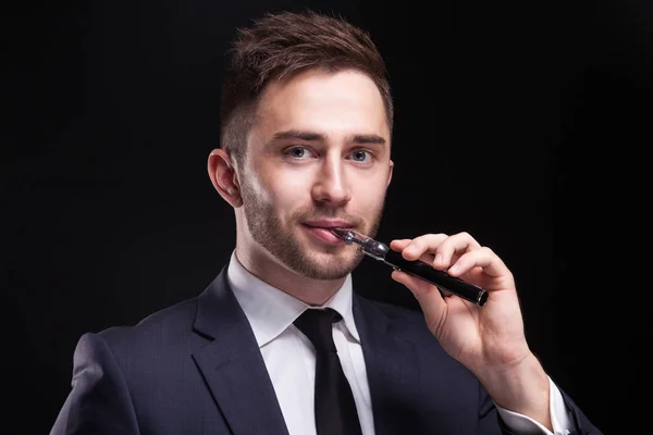 Jeune homme d'affaires fume cigarette électronique — Photo