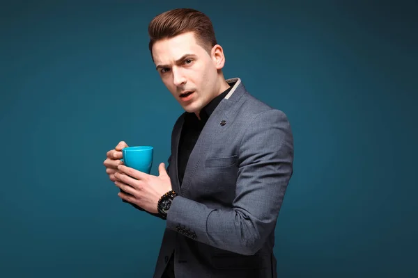 Joven hombre de negocios guapo con taza azul —  Fotos de Stock