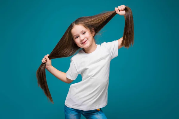 Linda chica morena sostiene el pelo —  Fotos de Stock