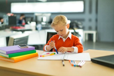 Ofiste genç çocuk çizer