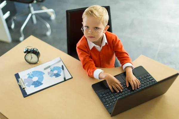 Cute boy in the office uses computer — Stock Photo, Image