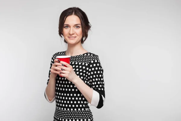 Attraktive Frau mit roter Tasse in der Hand — Stockfoto