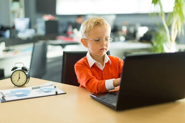 Carino ragazzo in il ufficio utilizza computer — Foto Stock