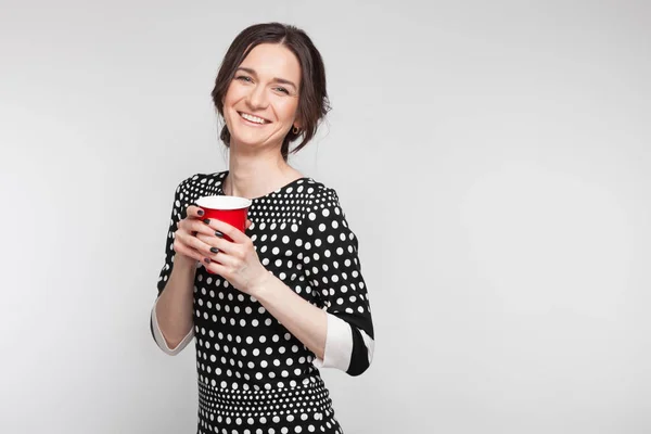 Attraktive Frau mit roter Tasse in der Hand — Stockfoto