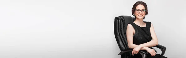 Mulher de vestido preto sentado na poltrona — Fotografia de Stock