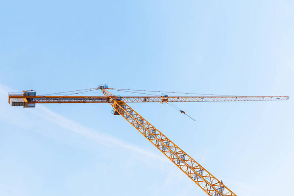 Building crane on the background of the sky and the object under construction