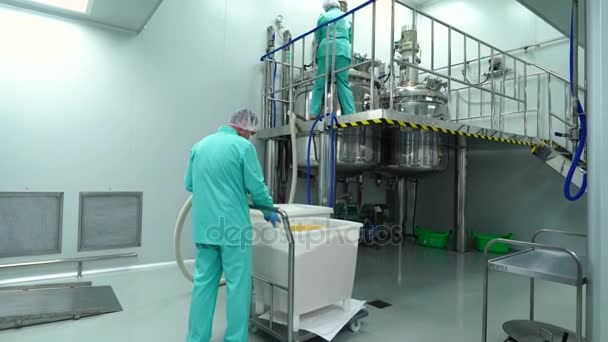Люди, работающие в форме, работают на фармацевтическом заводе — стоковое видео