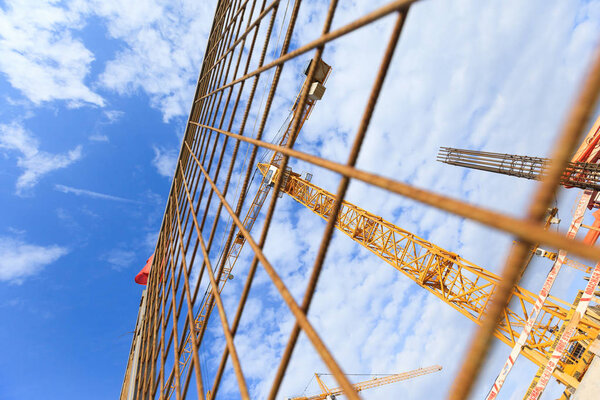 Building cranes on the background of the sky and the object under construction