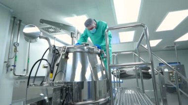 Fabrika içinde tank yakınındaki ayakta bilim adamı