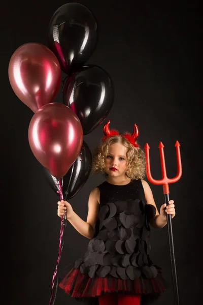 Malá holčička v kostýmu čert s balónky — Stock fotografie