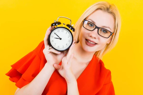 Emotional Young Woman Red Dress Holding Alarm Clock Yellow Background — Stock Photo, Image