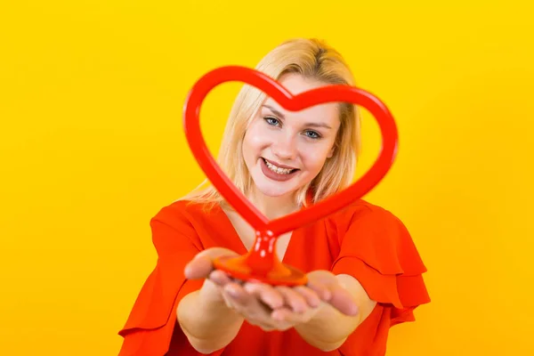 Mulher Bonita Vestido Vermelho Segurando Coração Vermelho Fundo Amarelo — Fotografia de Stock