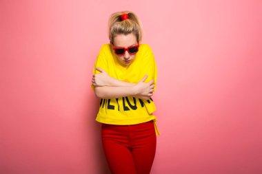 Parlak sarı tişört ve güneş gözlüğü pembe giyen genç ifade kadın