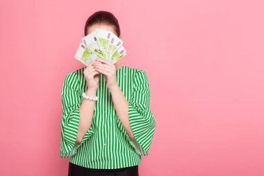 Şık gözlük euro banknot pembe studio arka planda tutan güzel genç kadın 
