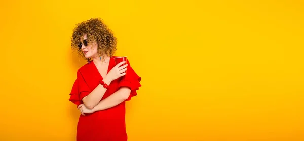 Atractiva Joven Mujer Pelo Rizado Vestido Rojo Gafas Sol Sosteniendo — Foto de Stock