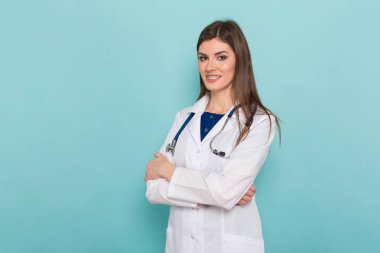 Kamera karşısına mavi arka plan, seyir stetoskop ile kendine güvenen genç bir kadın doktor 