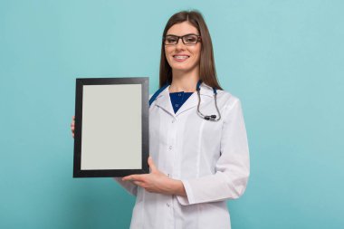 Boş çerçeve elinde stetoskop ile kendine güvenen genç bir kadın doktor 