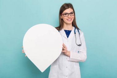 Boş kağıt harita işaretçi şeklinde elinde stetoskop ile kendine güvenen genç bir kadın doktor