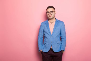 Mavi ceket ceplerinde pembe bir arka plan üzerinde el ele tutuşarak yakışıklı genç adam 