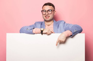 Boş afişini işaret eden yakışıklı genç 