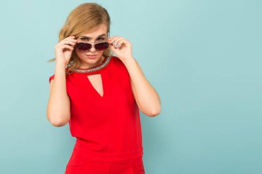 Genç sarışın kadın şık güneş gözlüğü ayarlama