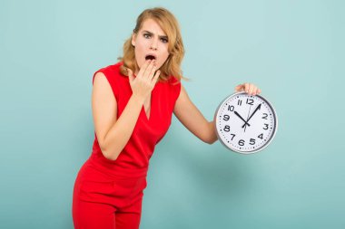 Genç sarışın bir kadın tutarak saat mavi stüdyo arka plan