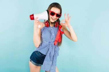 Hoparlör olarak konuşmak ve iyi jest gösterilen modern Kulaklığımda mutlu oldukça esmer kız