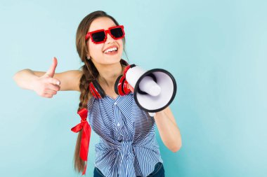 Hoparlör olarak konuşmak ve parmağıyla işaret modern Kulaklığımda mutlu oldukça esmer kız 