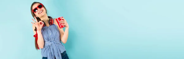 Hübsche Brünette Mädchen Modernen Kopfhörern Mit Plastikbecher Und Zeigt Geste — Stockfoto