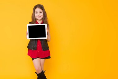 Sevimli küçük esmer kız dijital tablet sarı stüdyo arka planda tutan 