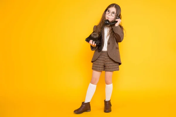 Niedliches Kleines Brünettes Mädchen Spricht Auf Altem Telefon Auf Gelbem — Stockfoto