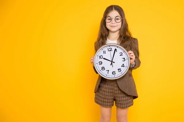 Niedliche Kleine Brünette Mädchen Hält Wanduhr Und Lächelt Die Kamera — Stockfoto