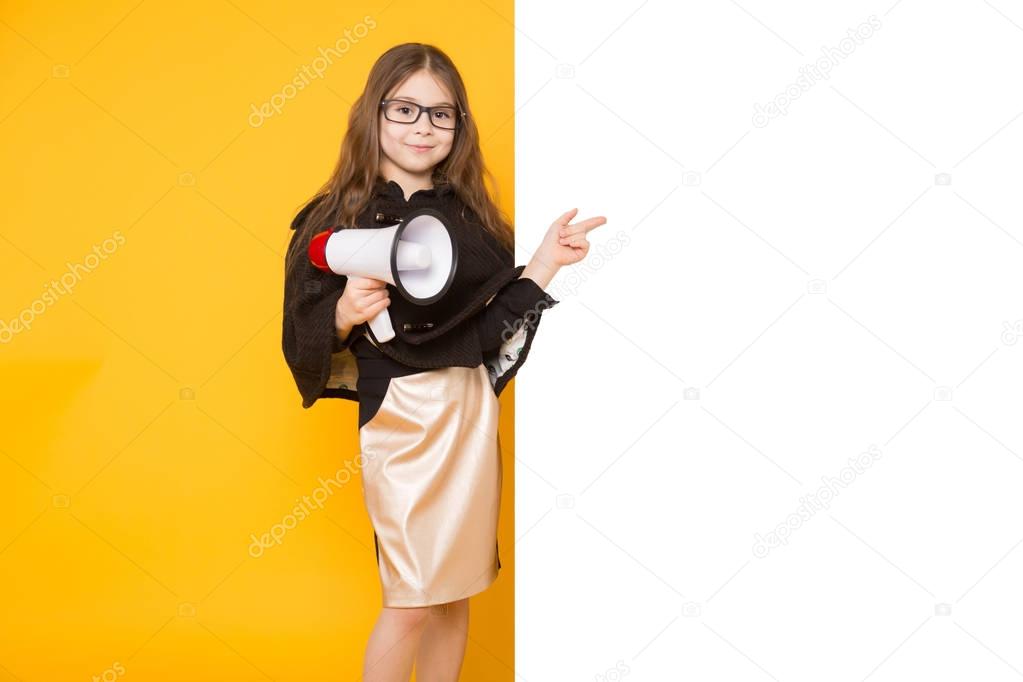 Cute little brunette girl with blank bilboard and megaphone on yellow background