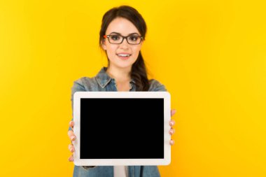 Genç esmer kadın gösteren dijital tablet ile boş perde