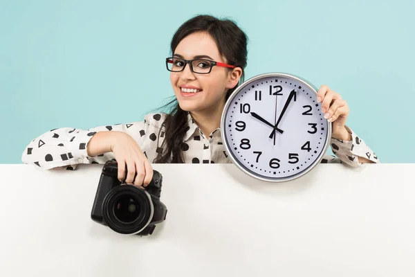 Μελαχρινή Νεαρή Γυναίκα Κατέχει Επαγγελματική Φωτογραφία Κάμερα Και Τοίχο Ρολόι — Φωτογραφία Αρχείου