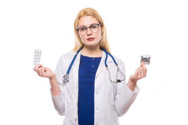 Prezervatif ve hapları tutan genç kadın doktor 