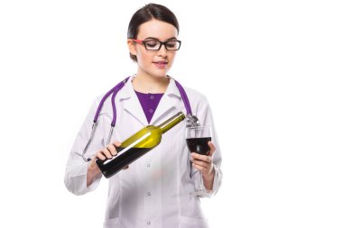 Kırmızı şarap cam dökme stetoskop ile genç kadın doktor 