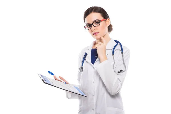 年轻沉思女性医生与剪贴板在白色背景下隔离 — 图库照片