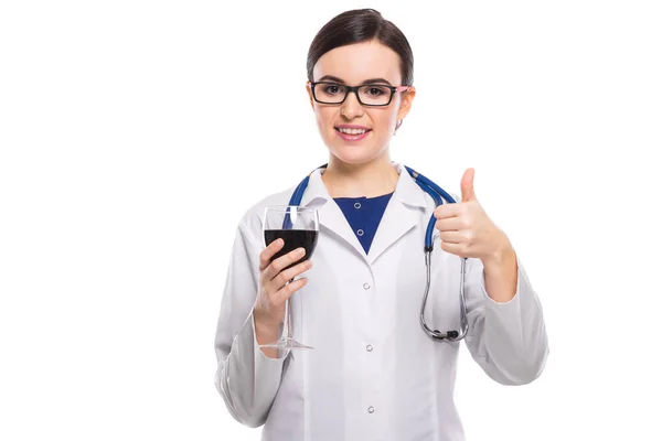 年轻女医生与听诊器持有红酒和显示拇指向上 — 图库照片